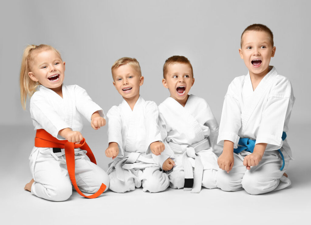 Young martial arts children showing ready stance while kneeling